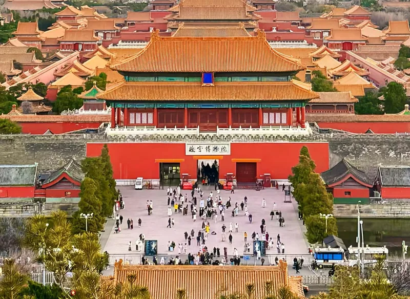 Visitors crossing a wide marble-terraced courtyard between the great halls