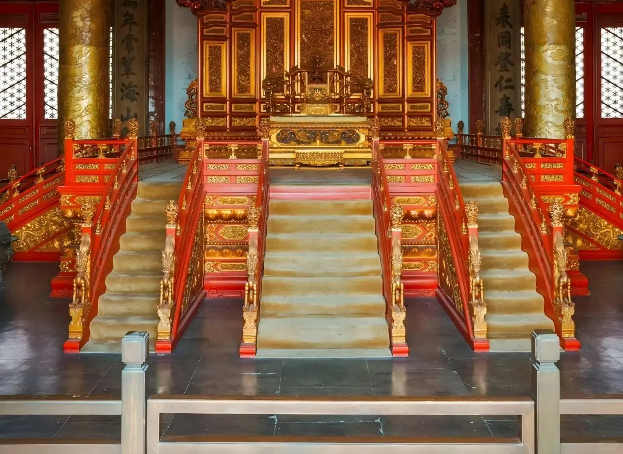 A gilded throne, red columns, marble stair, indoors